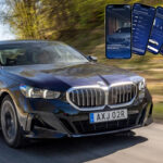 BMW 7-serien kör längs vägen med en smartphone-app aktiv. (AI text)