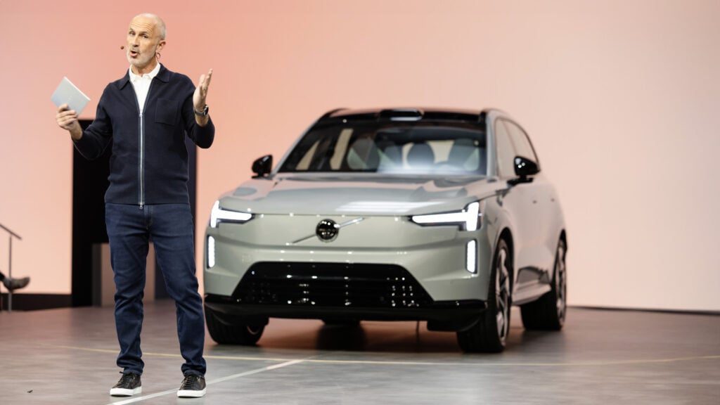 En man står bredvid en Volvo EV. (AI text)