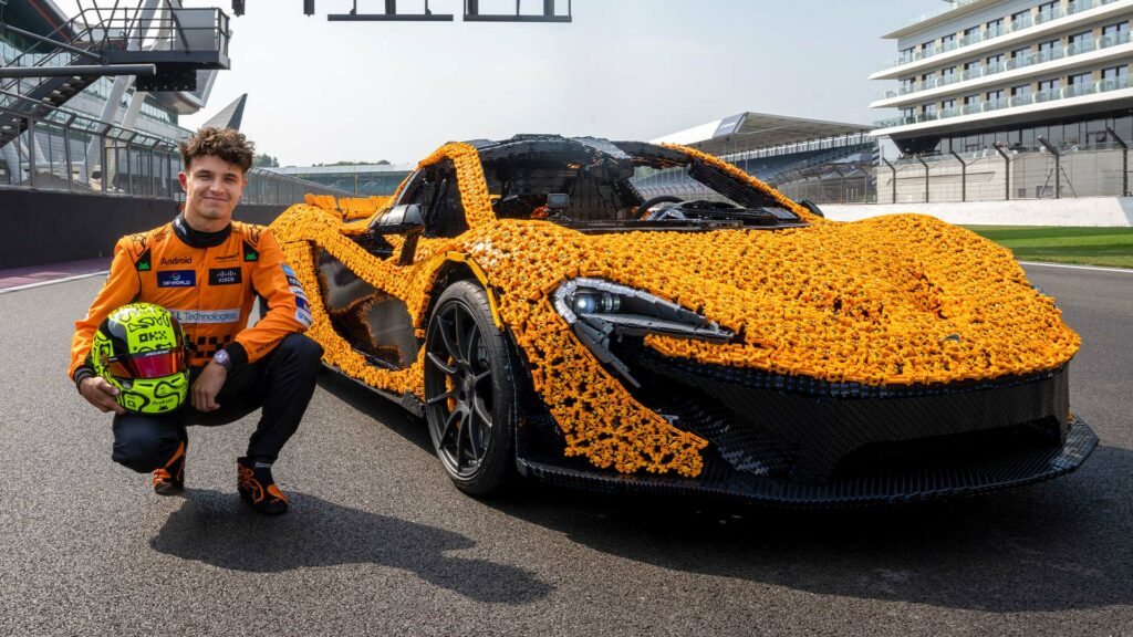 En man poserar med en Lego-bil. (AI text)