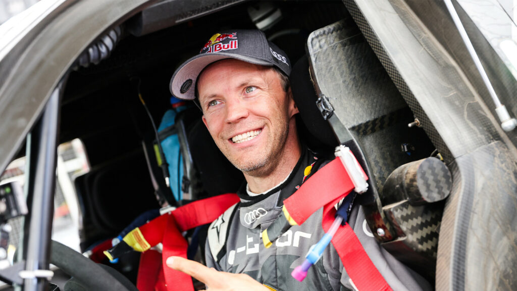 En man leende i en bil. (AI text)