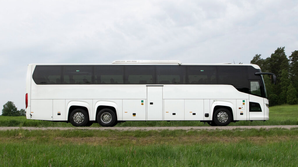 En vit buss parkerad på en väg. (AI text)