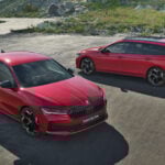 Två röda Skoda-bilar parkerade på en bergsväg. (AI text)