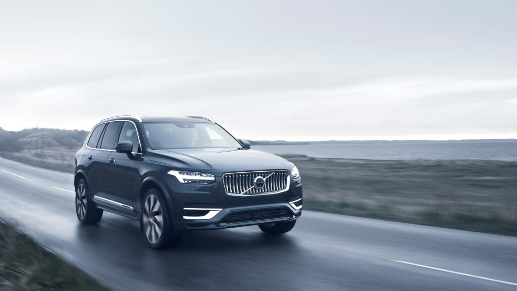 Volvo XC90-grevgående SUV kör längs en landsväg. (AI text)