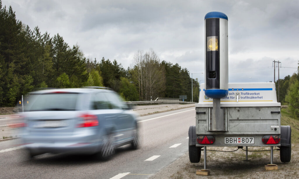 Blå Skoda Ocavia passerar en mobil fartkamera på en landsväg.
