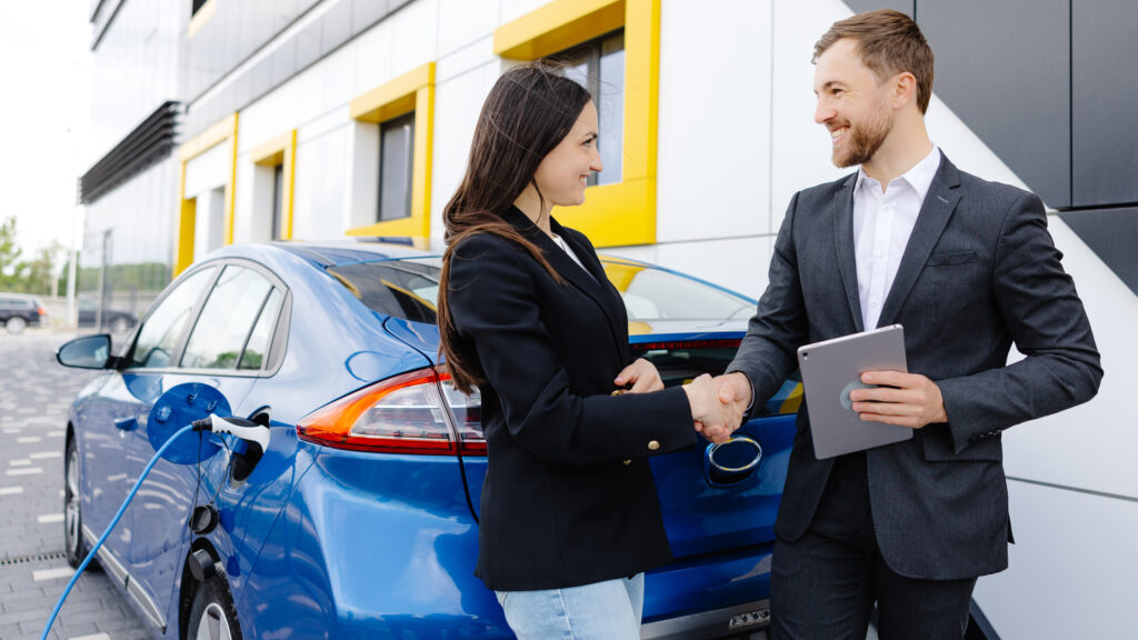 Kund och bilhandlare framför en Hyundai Ioniq.