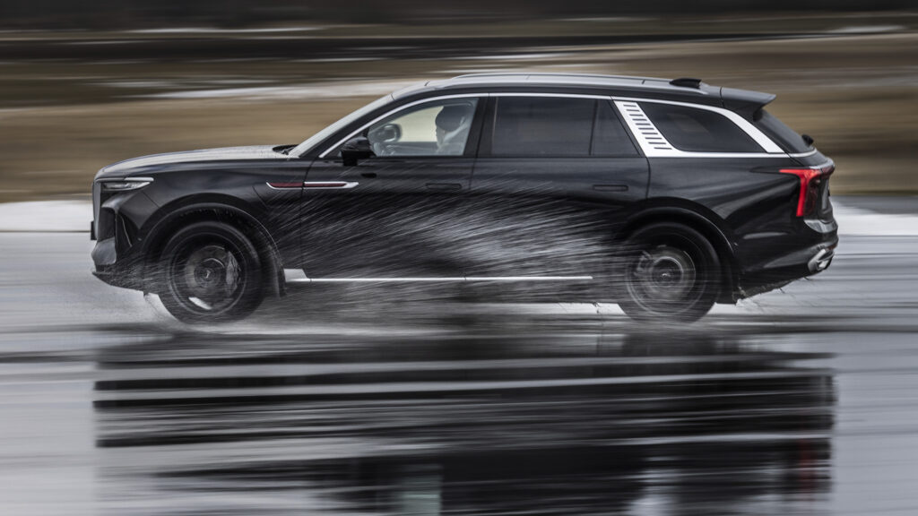 Svart Hongqi E-HS9 kör genom vattenpöl.
