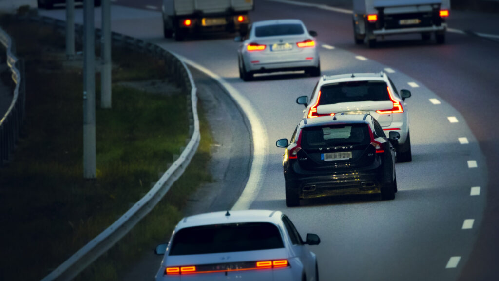 Volvo V60 kör med släcka bakljus i skymningen på motorväg.