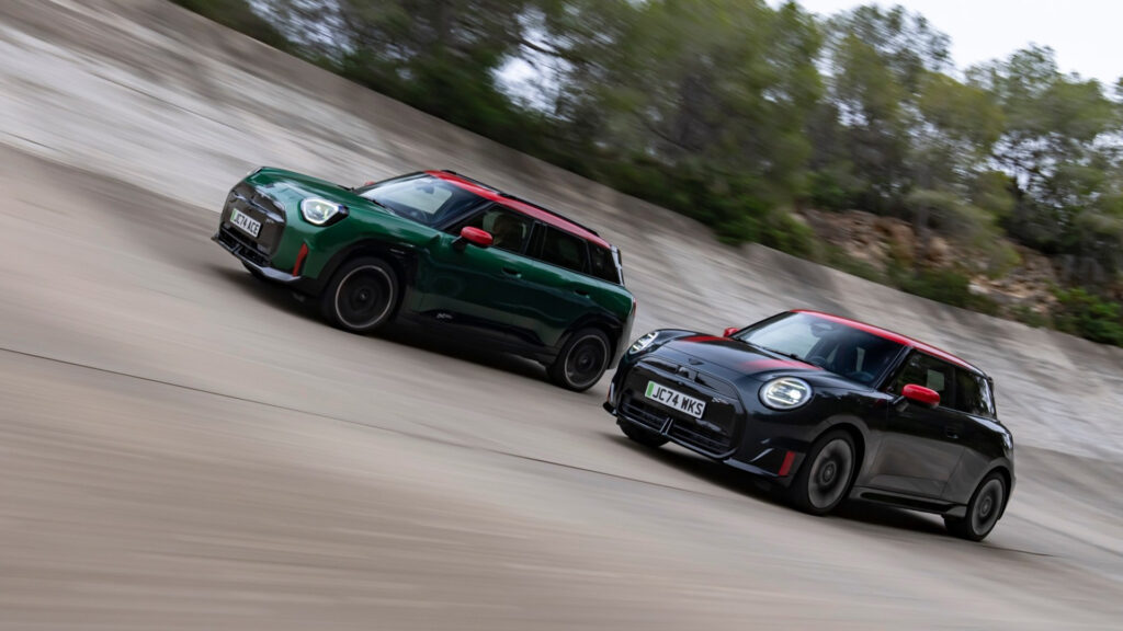 Två Mini Cooper kör nedför en backe. (AI text)