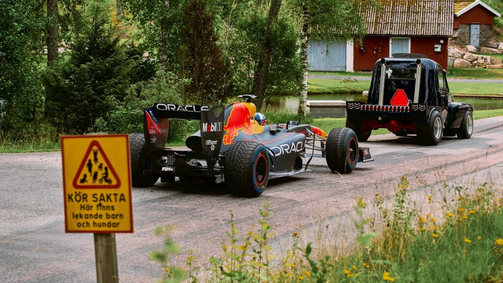 En racingbil kör längs en väg. (AI text)