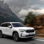 ŠKODA KODIAQ på bergsväg med vacker natur i bakgrunden.