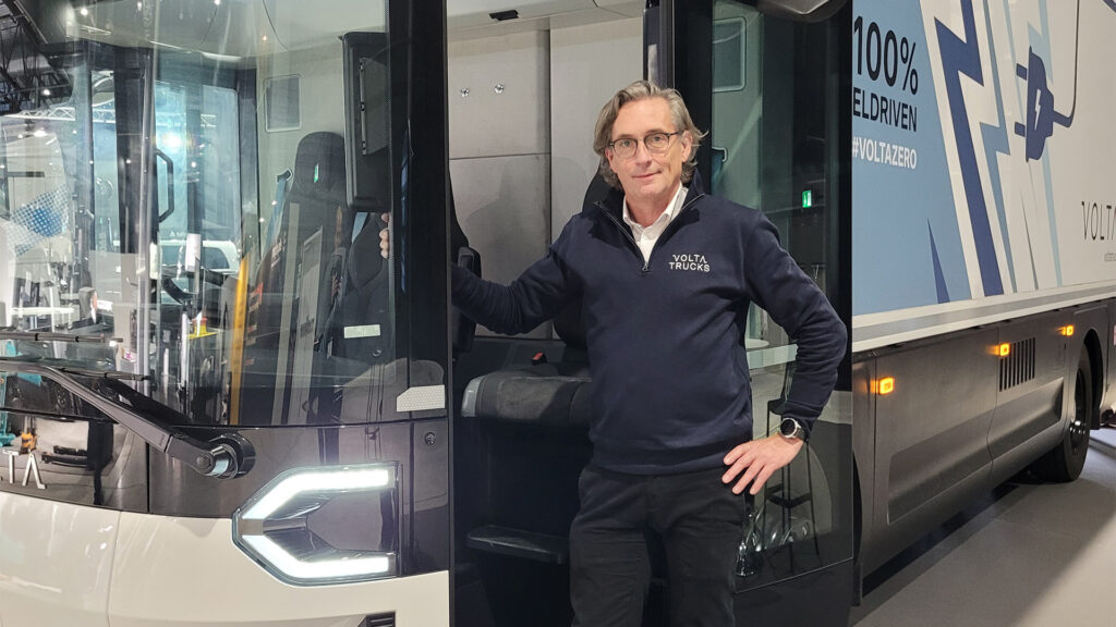 En man står bredvid en bus. (AI text)