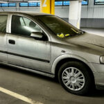 Extremt smutsig Opel med många parkeringsböter på rutan.