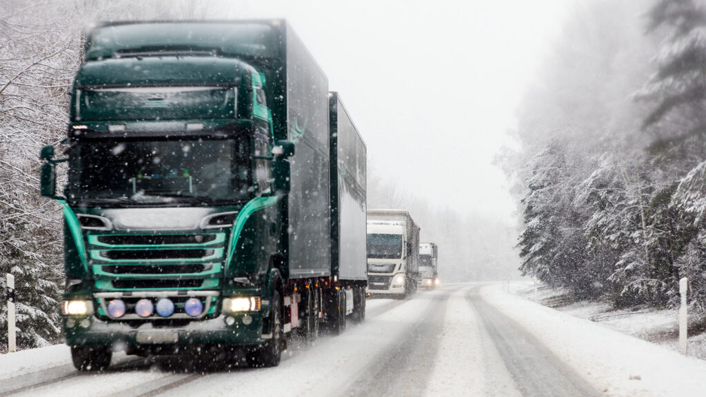 En lastbil kör på en snöig väg. (AI text)