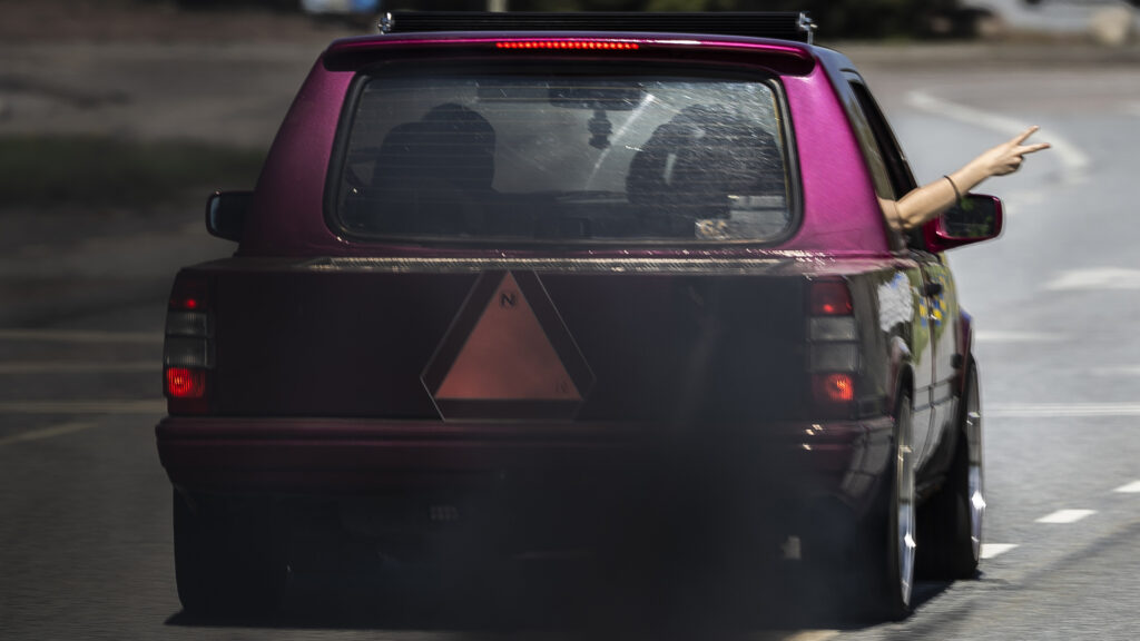 En kvinna kör en bil på en gata. (AI text)