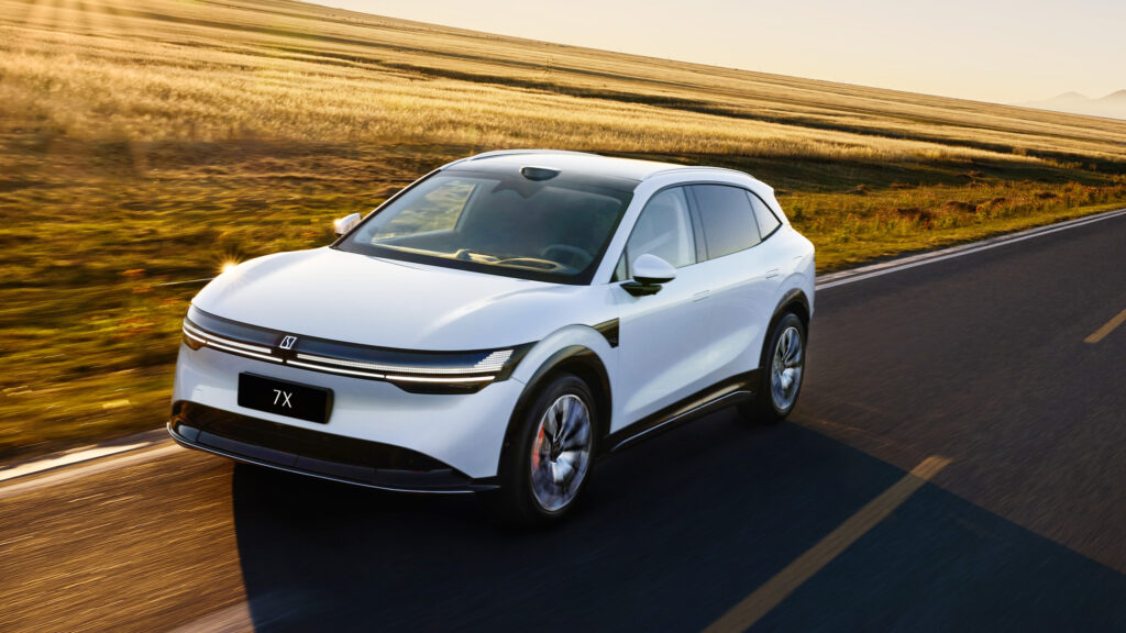 Vit Zeekr 7X på landsväg i solnedgång