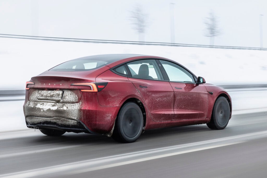 Tesla Model 3 snett bakifrån på vinterväg