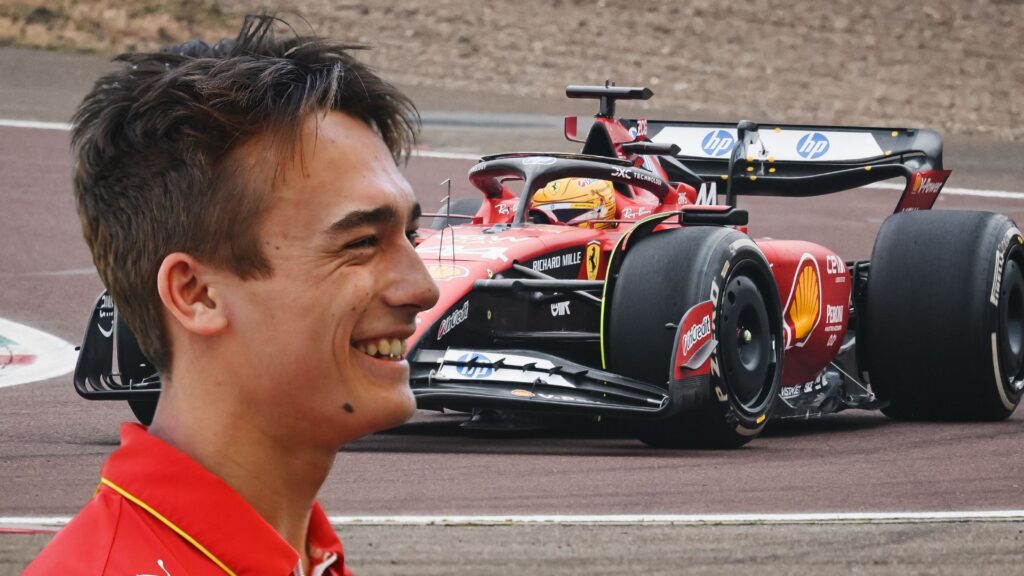 Dino Beganovic, leende i Ferraris teamkläder, med en Ferrari F1-bil i bakgrunden under tester på banan.