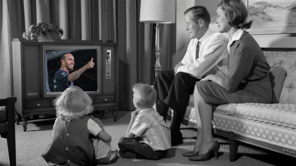 En retrobild av en familj som sitter i vardagsrummet och tittar på en Formel 1-sändning på en gammal TV, där Lewis Hamilton gör tummen upp.
