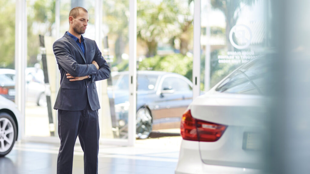 Man ser skeptiskt på en bil i en bilhall.