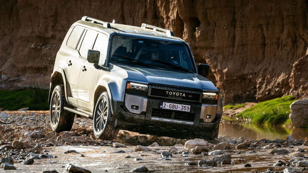 En Toyota Land Cruiser kör genom en stenig terräng.