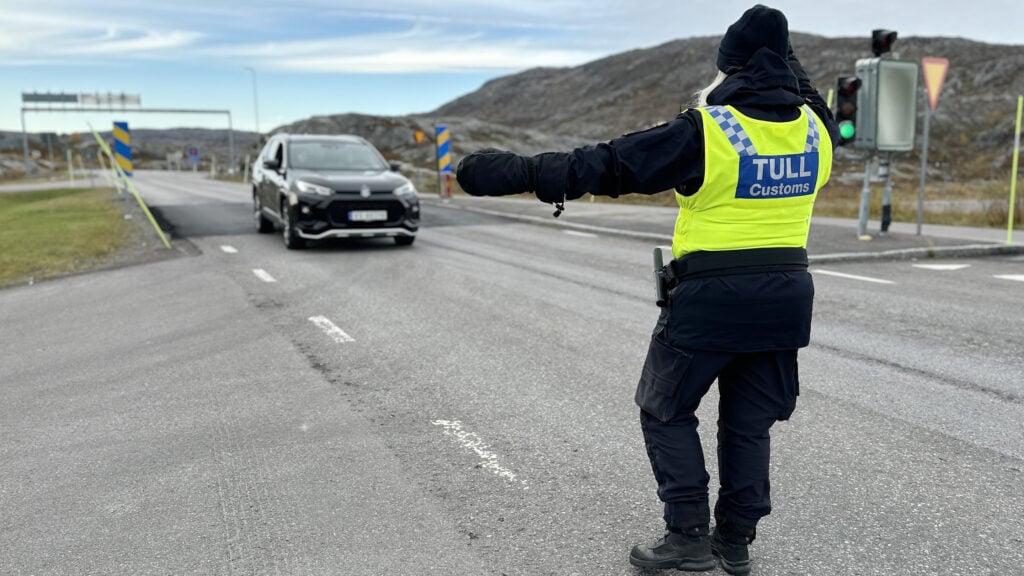Tullare stoppar personbil vid gränsen.