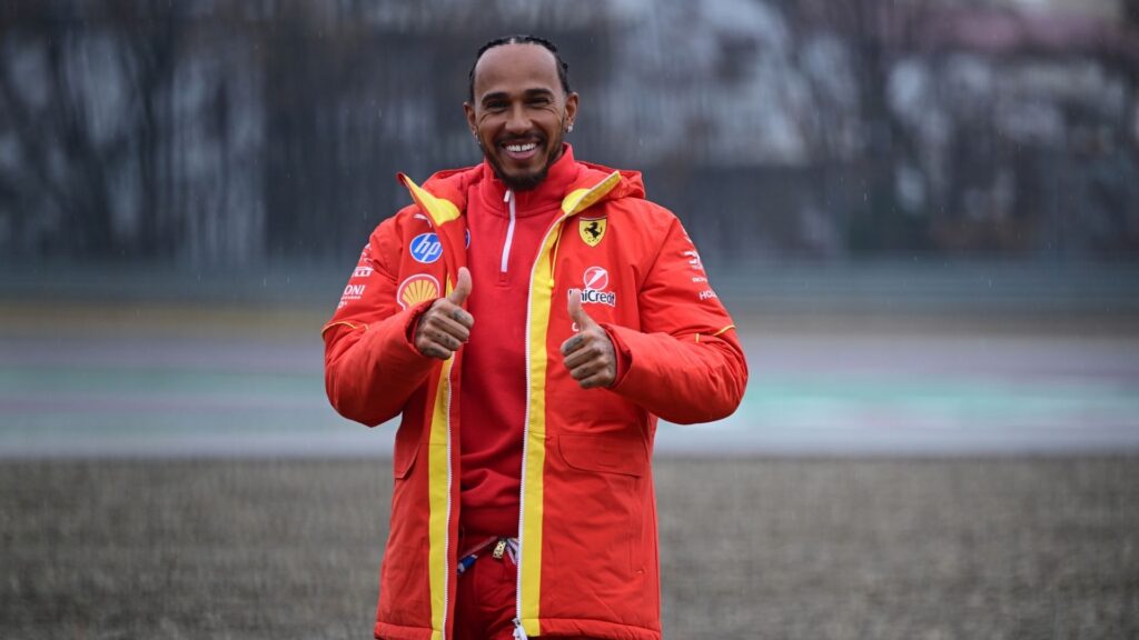 Lewis Hamilton i Ferrari-kläder ger tummen upp under en regnig dag på banan. Den sjufaldige världsmästaren är redo för sin första säsong med Scuderia Ferrari.