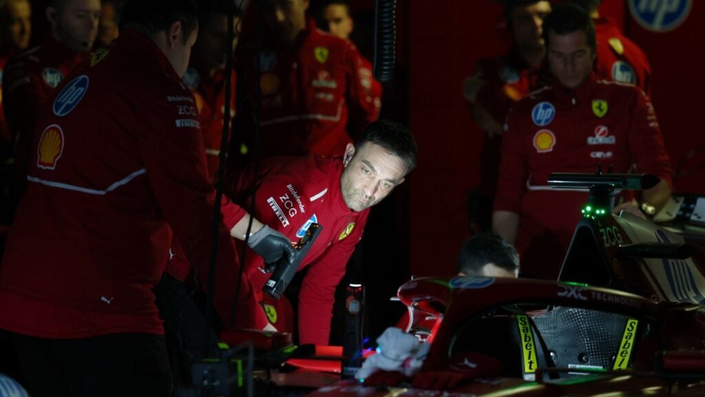 Ferrari-mekaniker inspekterar en bil i mörker med ficklampor under Formel 1-test i Bahrain efter ett strömavbrott.