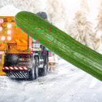 Gul lastbil som saltar vinterväg och en gurka