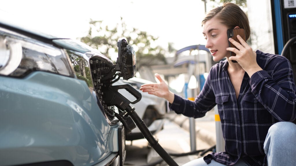 Kvinna har prblem med att ladda sin elbil.