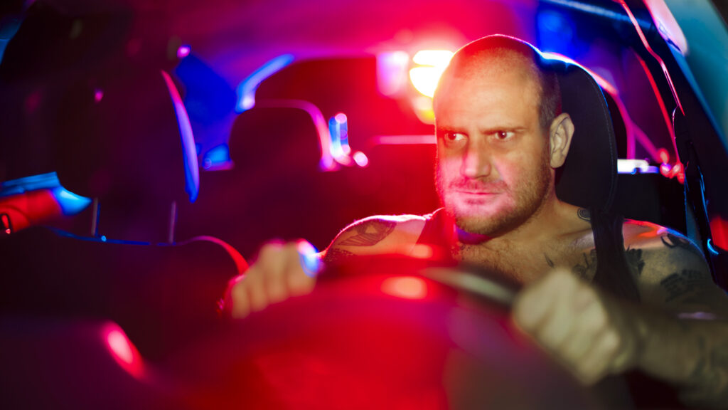 Kriminell som stoppas av polisbil bakom.