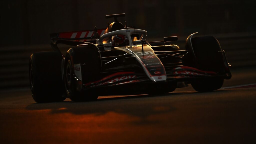 En Haas F1-bil i skymningen med mörka konturer, vilket ger en mystisk känsla och förstärker osäkerheten kring bilens detaljer.