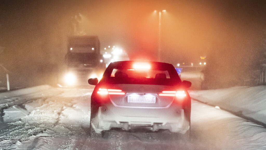 bil och lastbilar på mycket snöig väg.