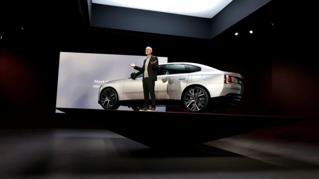 Volvo ES90 presenteras på scen under lanseringseventet. En person står framför bilen och gestikulerar medan den upphöjda plattformen ger bilen en dramatisk inramning.