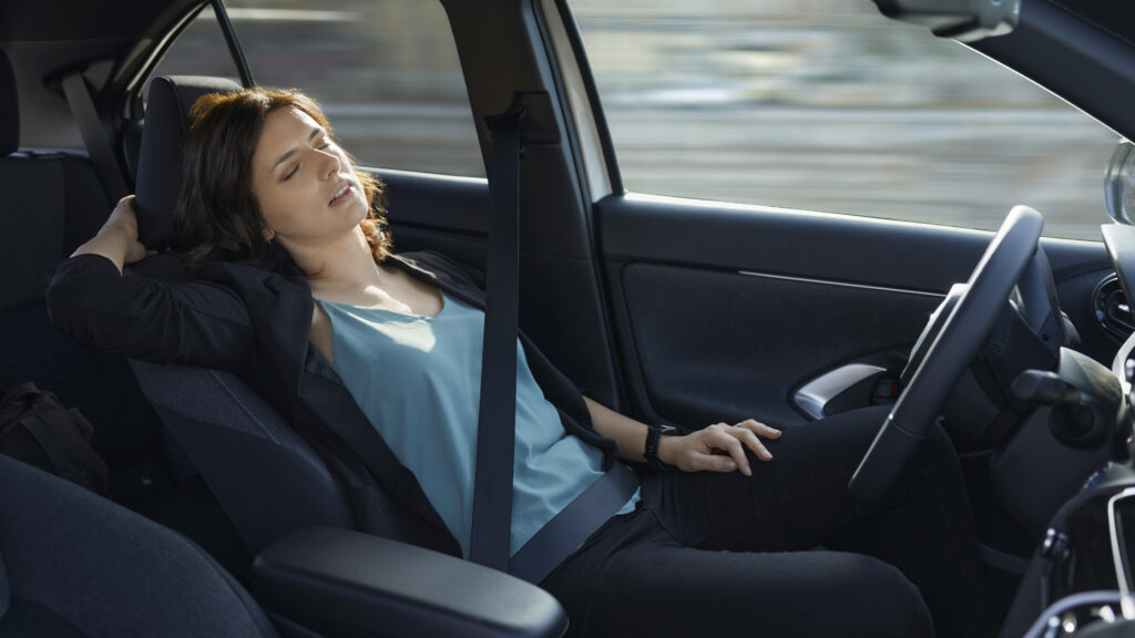 Kvinna sover i förarsätet under färd.