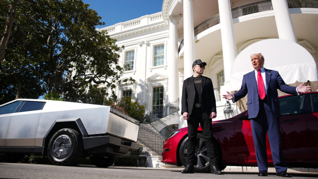 Elon Musk och Donald Trump utanför Vita huset tillsammans med flera Tesla-bilar.