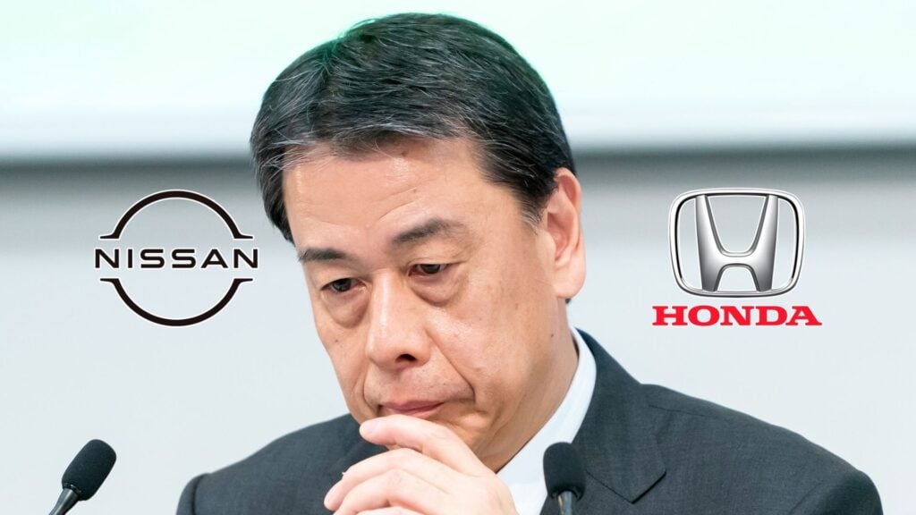 Nissan-VD Makoto Uchida ser sammanbiten vid en presskonferens, med Nissan- och Honda-logotyper i bakgrunden, mitt i spekulationer om sin avgång och en möjlig återupptagen fusion mellan bolagen.