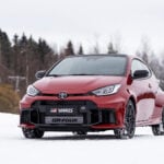 Röd Toyota GR Yaris snett framifrån på snö.