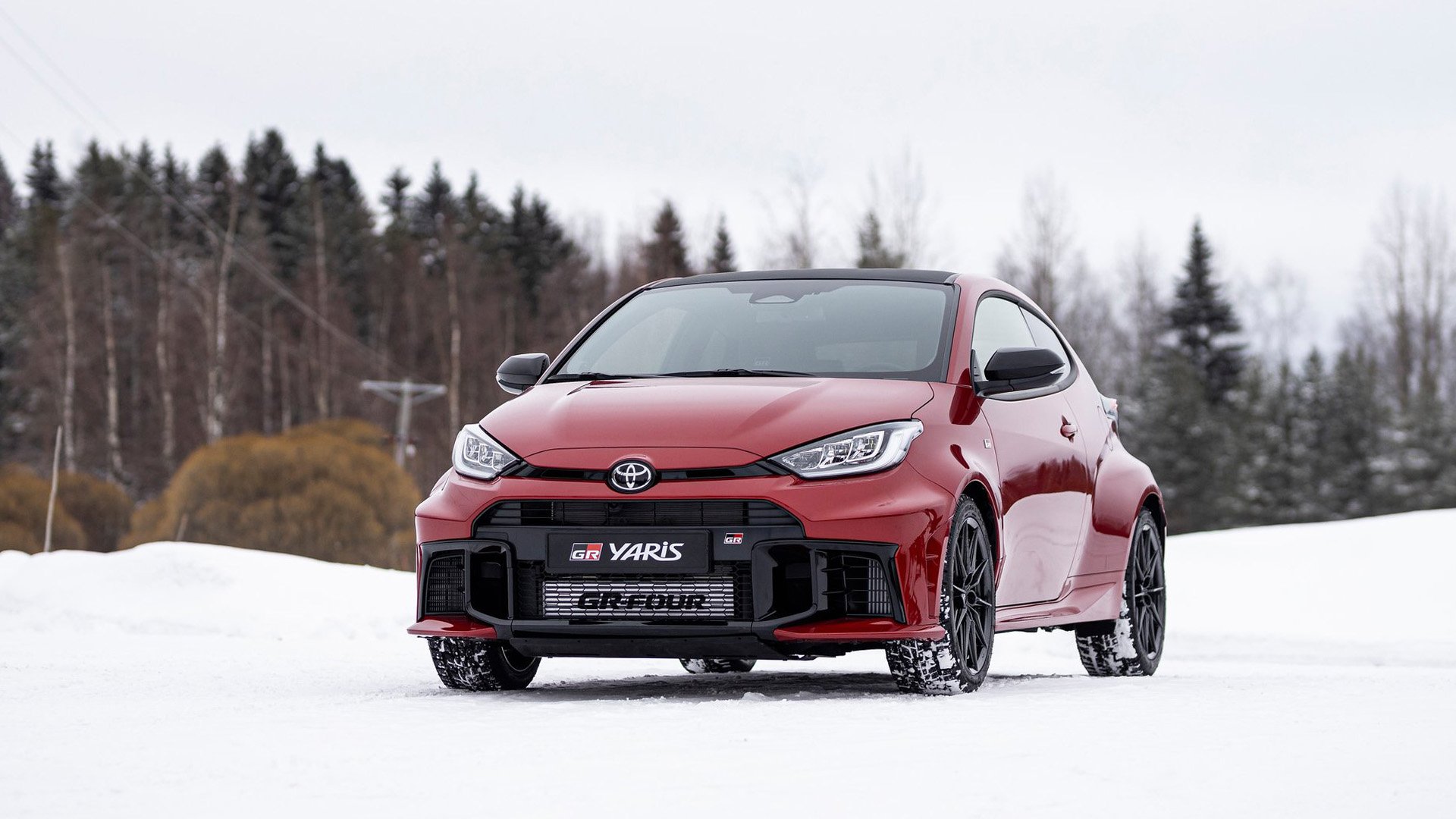 Röd Toyota GR Yaris snett framifrån på snö.