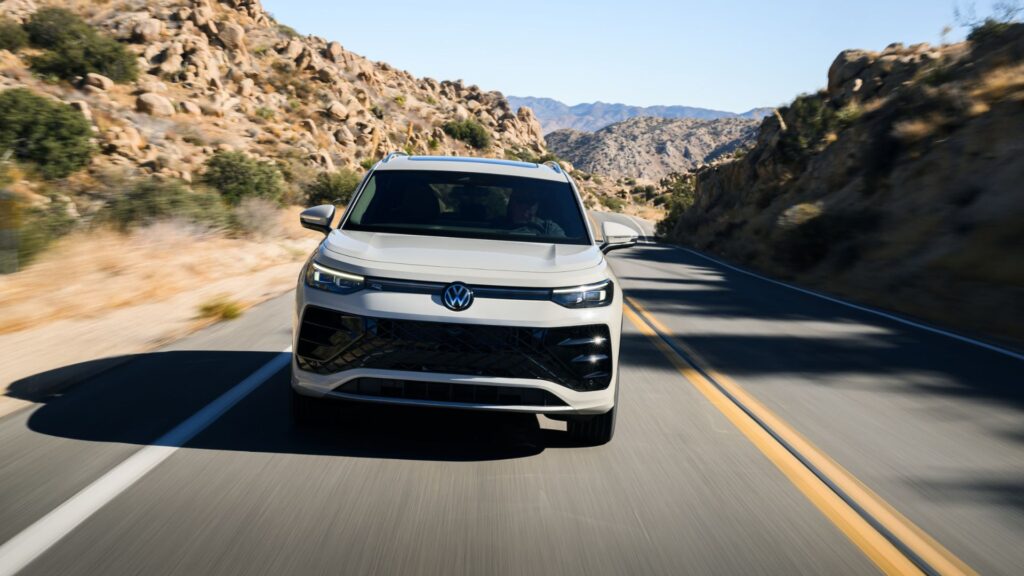 Volkswagen Tiguan körs på slingrande landsväg i bergig miljö, sedd framifrån.