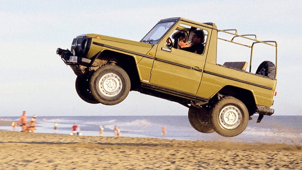 Mercedes G 460 hoppar i sanden på en strand.