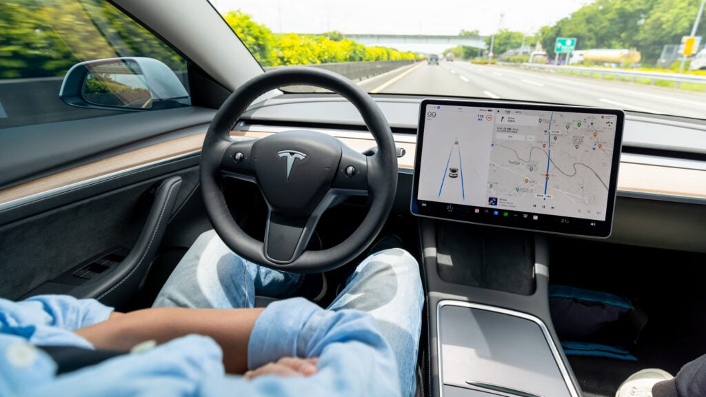 Tesla kör av sig själv på motorväg.