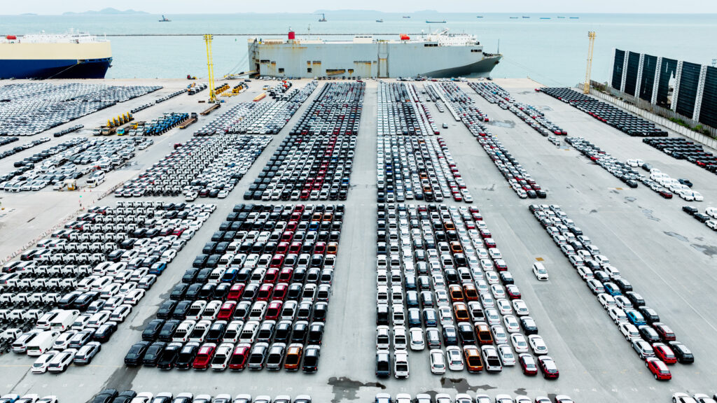Bilar i hamn som ska lastas på ett fartyg.