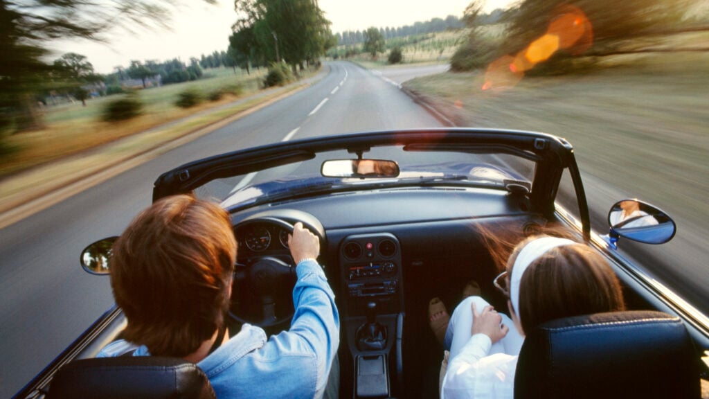 Två personer i en öppen sportbil