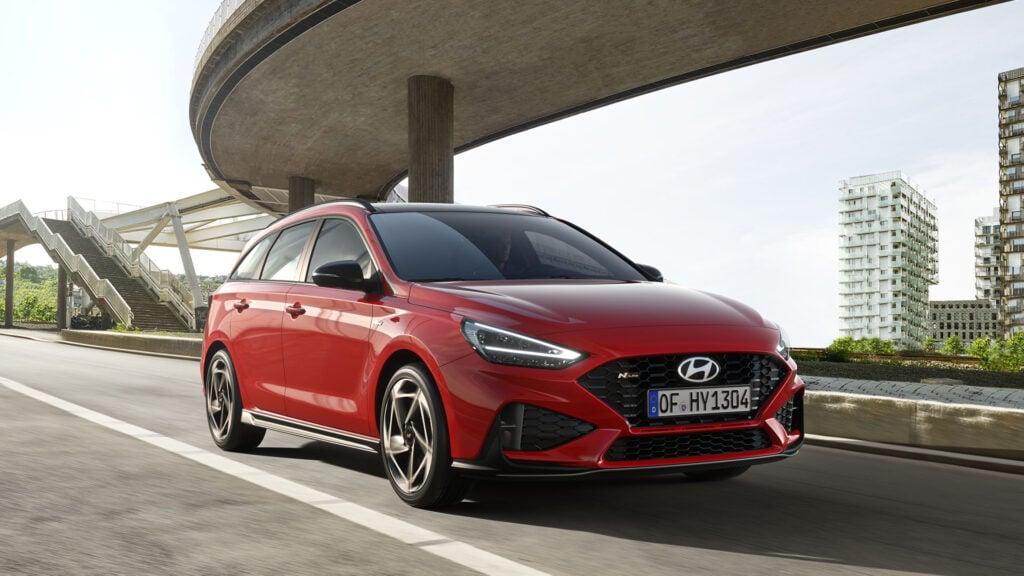 En röd Hyundai i30 kör i stadsmiljö.