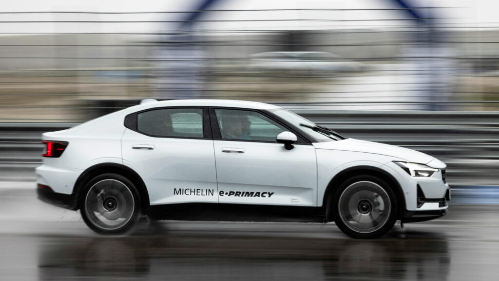 Vit Polestar 2 kör på våt vägbana.