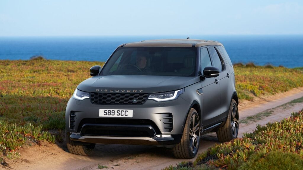 Land Rover Discovery Tempest 2025 i matt grå lack på grusväg vid kusten.