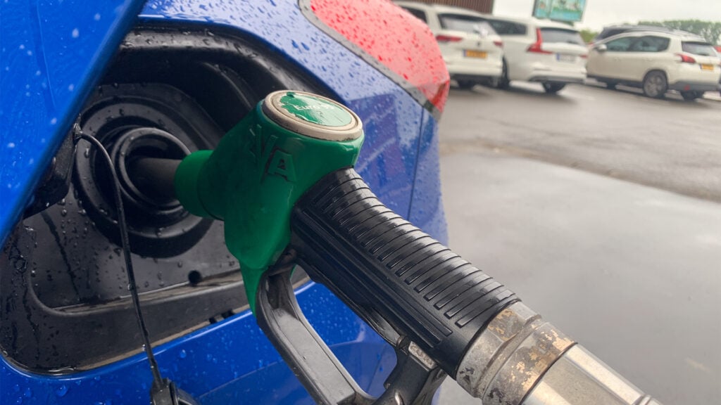 Bensinpump tankar en blå bil.