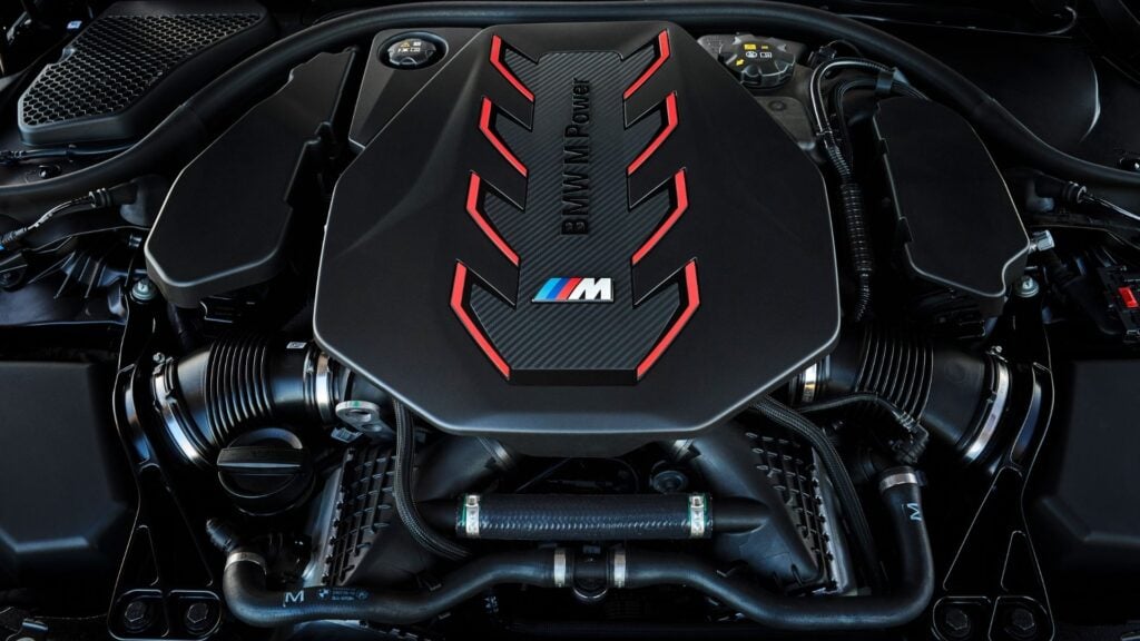 Närbild på V8-motor i BMW M5 2025 med M Power-logotyp och röda designelement.