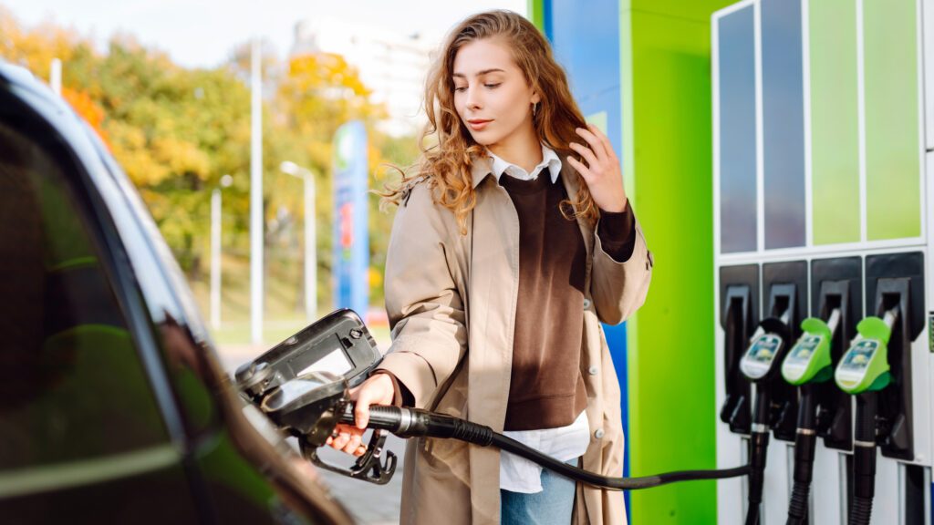 Ung kvinna tankar sin bil