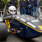 KTH Formula Student-bil med stundenter omkring bilen.